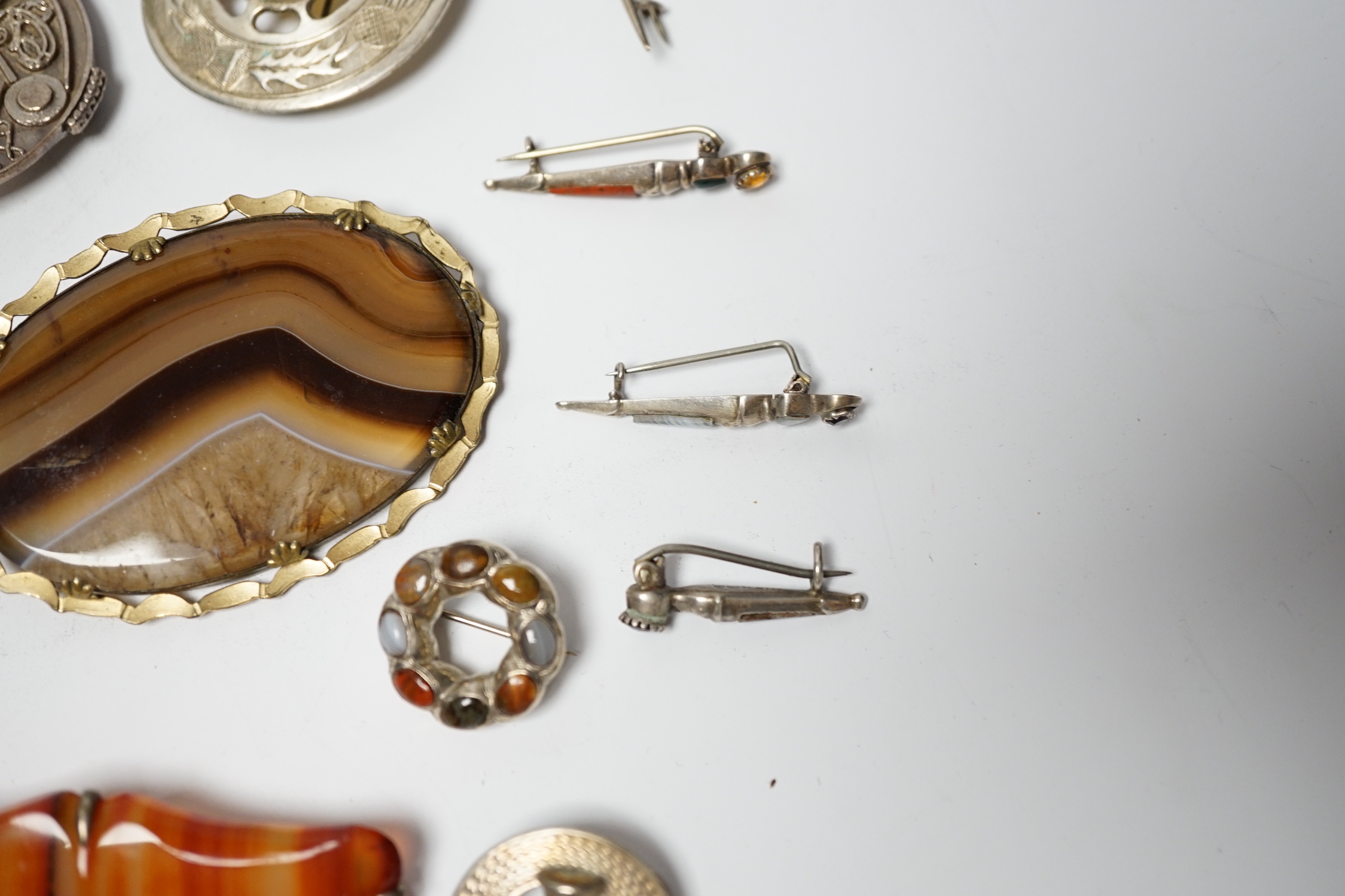 A small collection of mainly silver, sterling and white metal jewellery including Celtic brooches, Iona ship brooch, a Scottish hardstone set bugle brooch and other moss agate set and banded agate set items, largest broo